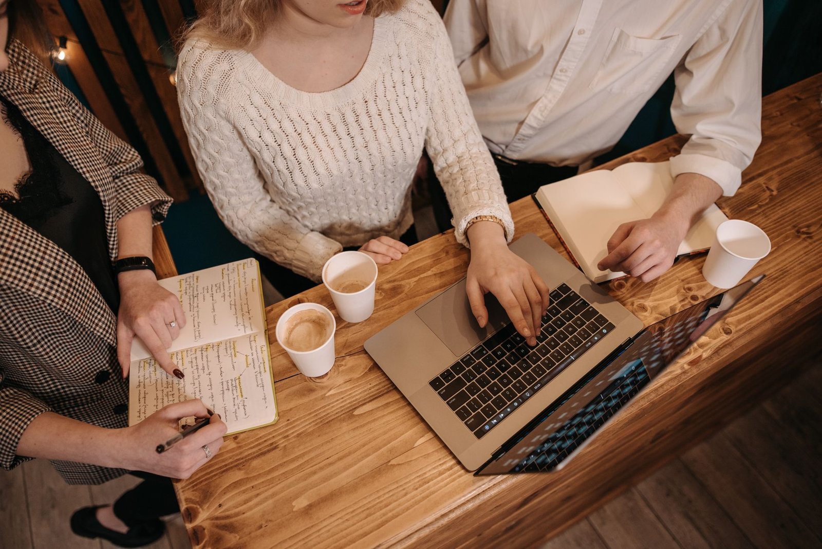 Top view of a collaborative team meeting with laptops and coffee at a wooden table. — Free no deposit crypto casino